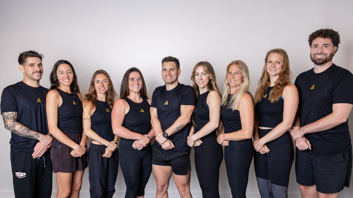 The Kinetic Blueprint team, nine practitioners in studio kit, Austin TX